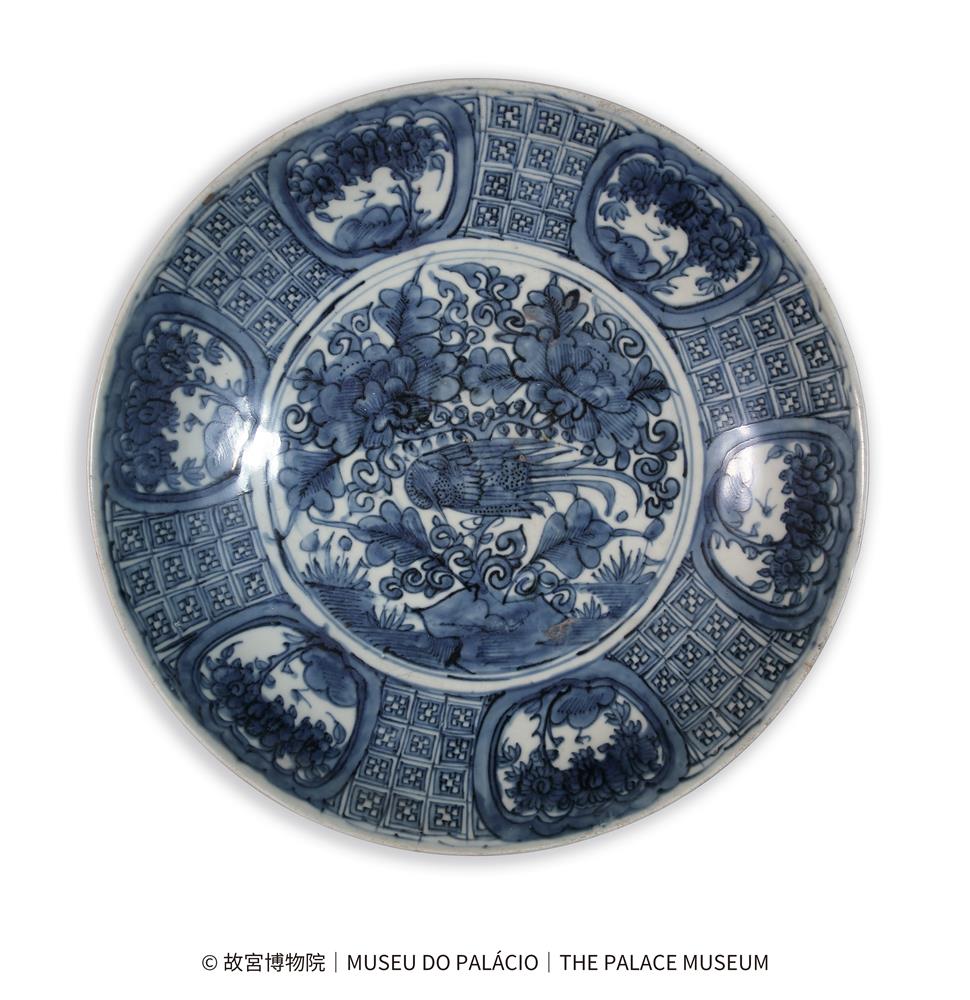 <p>漳州窯青花錦地開光花鳥圖盤<br />
明萬曆<br />
高10釐米 口徑42.5釐米 足徑23.5釐米<br />
故宮博物院</p>
<p>盤敞口微外撇,淺弧腹,淺圈足。通體青花裝飾。盤內壁繪6組開光,開光內繪花卉紋,間飾錦格紋,內底繪山石花鳥圖。圈足內施白釉無款識,足端無釉,底足粘滿窯渣,露胎處泛火石紅色。此盤青花發色藍中泛灰,釉面開片,筆觸粗獷,應為明代萬曆時期福建漳州平和窯產品。<br />
此類風格的克拉克瓷盤是明末清初外銷瓷的重要品種,遠銷歐洲,主要為青花品種,也有少量的五彩瓷。</p>