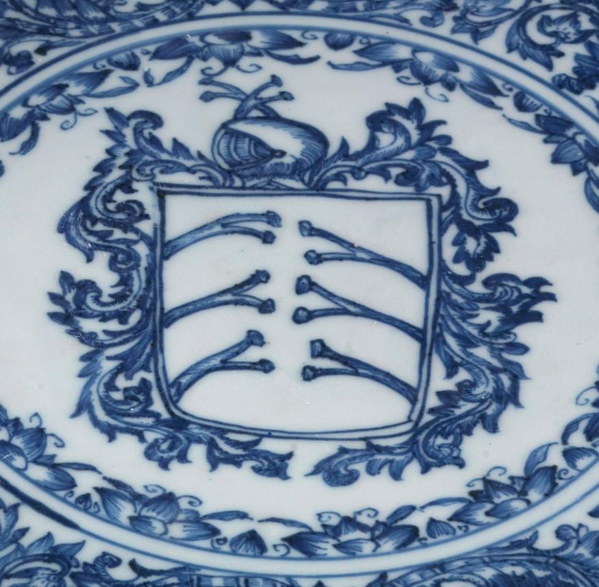 <p><span style="color: rgb(8, 8, 9); font-family: "Segoe UI Historic", "Segoe UI", Helvetica, Arial, sans-serif; font-size: 15px;">此瓷盆製於1690至1710年間，作為淨禮儀式中的盥洗器具，其造型或仿照歐洲金屬器皿原型，相信是源自葡萄牙。盆的中央繪有葡萄牙&ldquo;科斯達&rdquo;家族的紋章，周圍環繞著雙圓的小花。盤心中央繪有盾形紋章，盾內有六根肋骨，為科斯塔（Costa）家族的紋章，&ldquo;Coast&rdquo;的拉丁語意為肋骨，故其紋章的盾上飾有白色肋骨。盾牌上方飾有頭盔，頭盔上有肋骨，兩側飾以卷草。</span></p>
